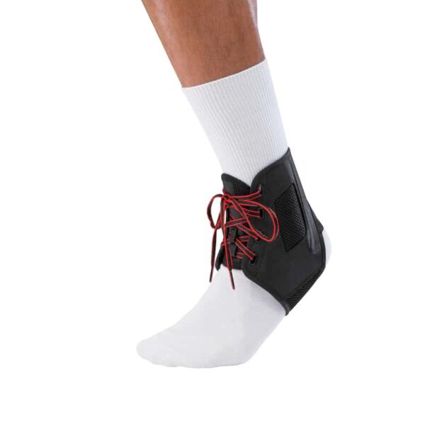 ATF® 3 Ankle Brace - מגן קרסול לתמיכה של Mueller שחור מבית מולר עם שרוכים אדומים על רגל שמאל של גבר עם גרב לבנה מבט מקדימה